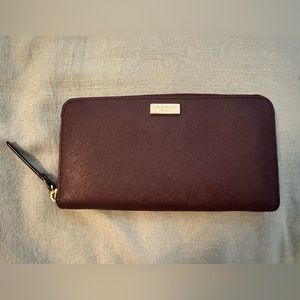 Kate Spade accordion style wallet. Burgundy/purple color, gold logo and zipper.